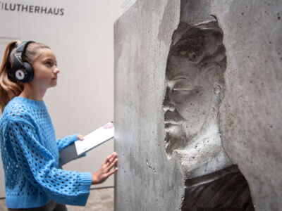 Schülerin mit AudioGuide an der Ai Weiwei - Skulptur "man in a cube" im Lutherhaus Eisenach
